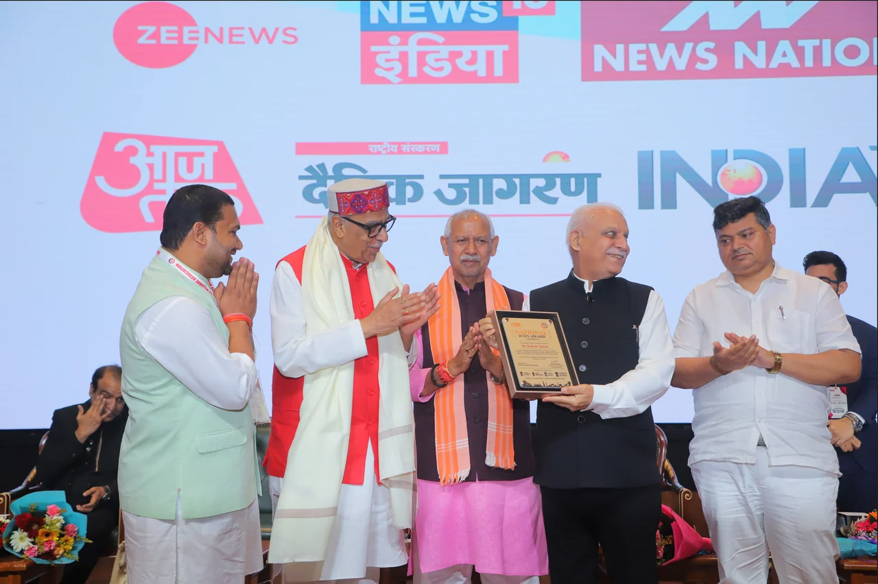Dr. Rajesh Takyar receiving the National Icon Award 2026 — Season 10 at Bharat Mandapam, New Delhi, on 13 October 2026. This photograph captures the presentation of the framed award at the ceremony organised by Bharti Yuva Welfare Association.